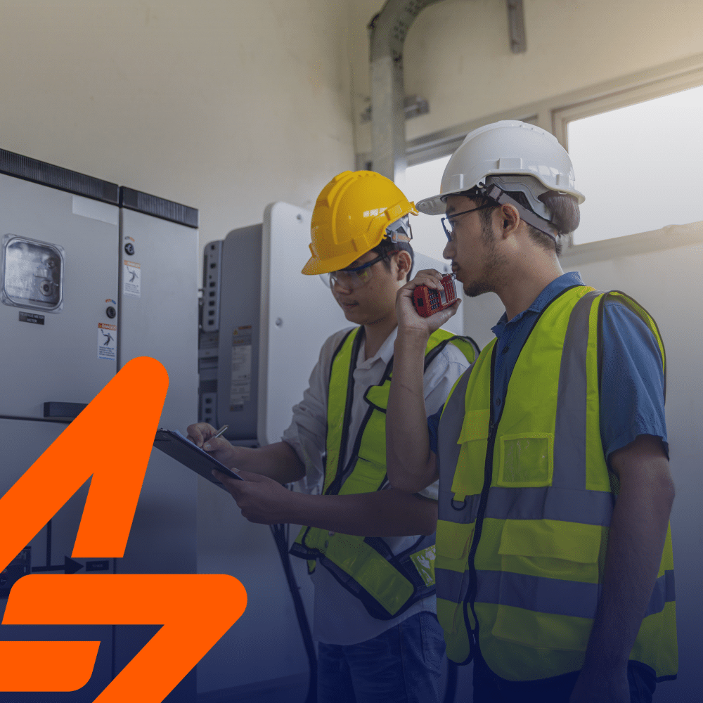 Industry clarity for electrical compliance - electricians in safety vests reviewing indoor switchgear