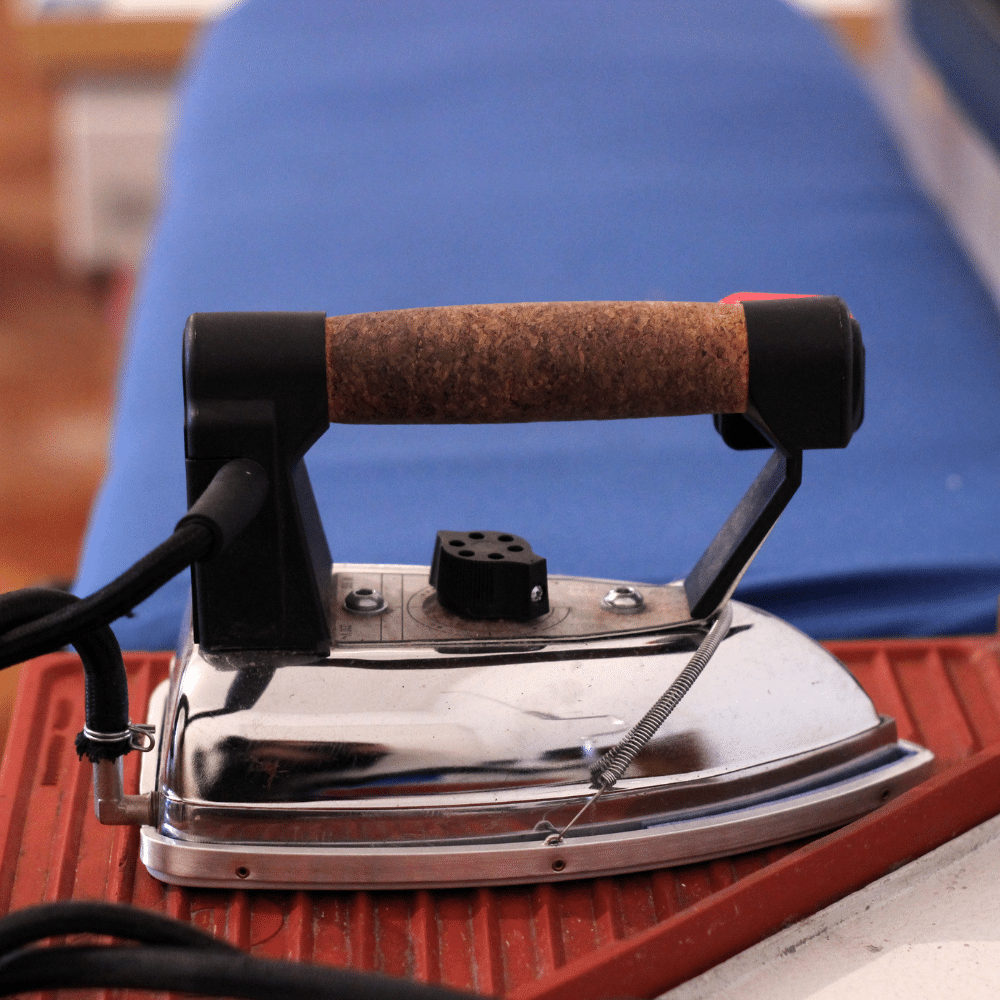 Industry clarity for electrical compliance - vintage industrial steam iron with cork handle on ironing board