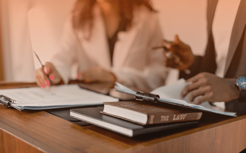 SA electrical compliance issues legal review - professionals signing compliance documents with law book